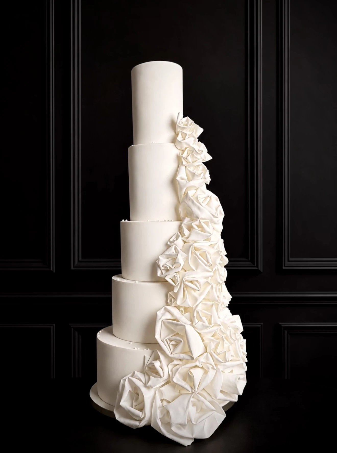 Five-tier ivory sculptural cake with cascading dimensional folded edible roses