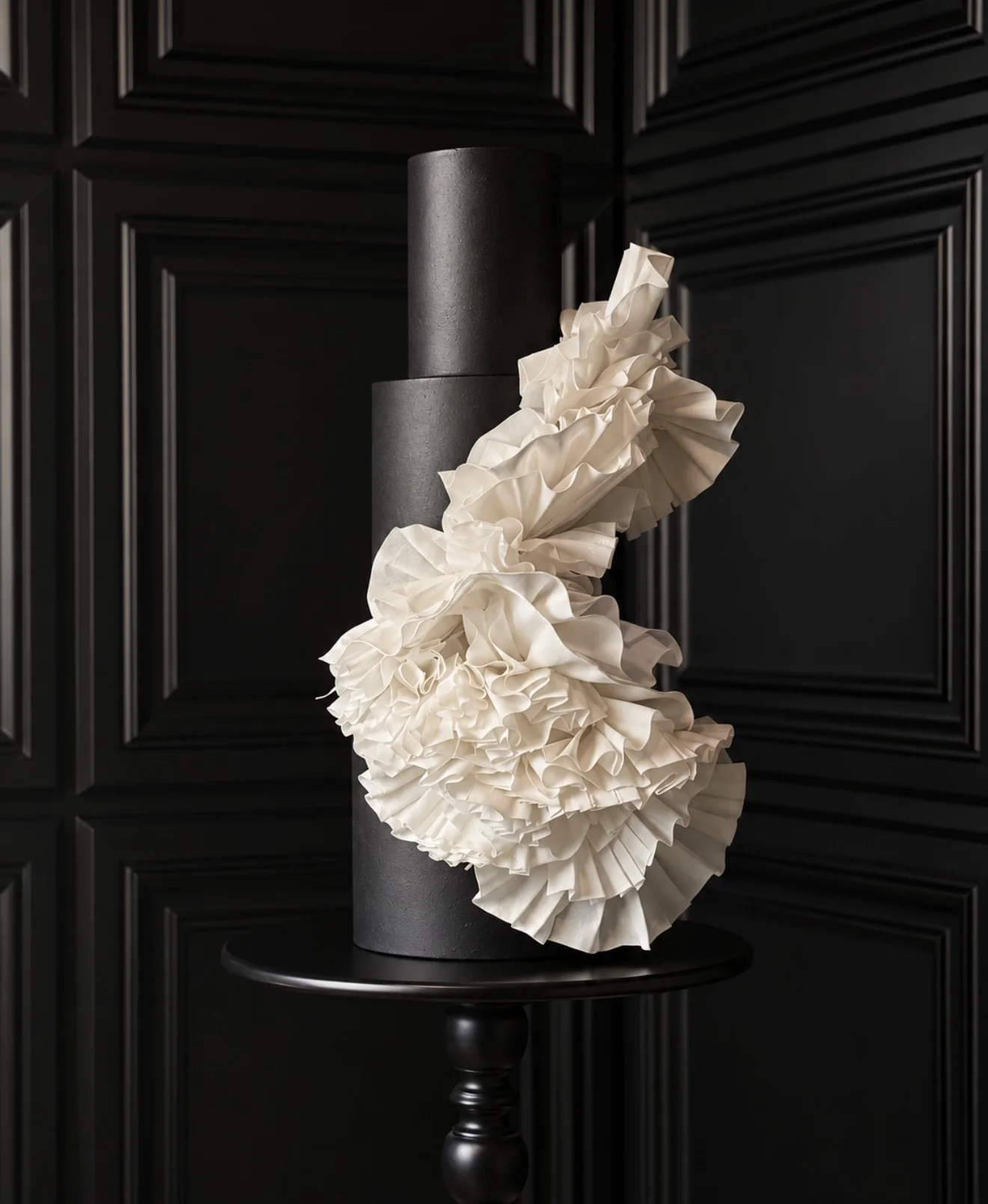 Black sculptural cake with cascading ivory ruffles